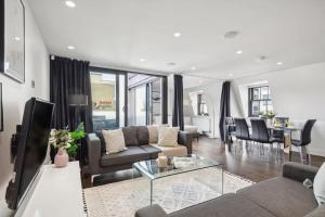 a living room with a couch and a table at 3BR Penthouse with Terrace - CityApartmentStay in London