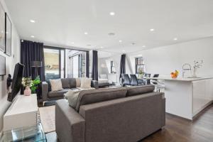 a living room and kitchen with a couch and a table at 3BR Penthouse with Terrace - CityApartmentStay in London