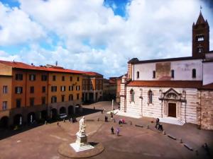 una piazza della città con una chiesa e una torre dell'orologio di Appartamento Piazza Dante Alighieri a Grosseto
