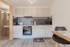 uma cozinha com armários brancos e um forno em Charmant studio rénové à Grimentz em Grimentz