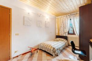 um quarto com uma cama e uma cadeira em Casa Perry - Lago Maggiore em Borgo Ticino