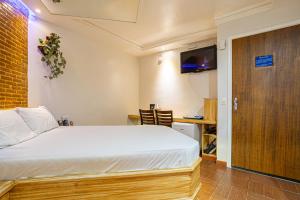 Dormitorio con cama, escritorio y TV en Hotel Coqueiros 2 en Carapicuíba