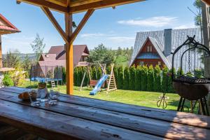 een houten tafel met uitzicht op een speeltuin bij Apartament GóralSki z widokiem na tatry in Brzegi