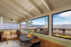 a balcony with a table and chairs and solar panels at Kona Shores 221 STVR #19-390879 in Kailua-Kona