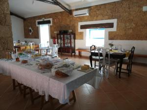 - une salle à manger avec une table et de la nourriture dans l'établissement Monte da Fonte Santa de São Luís, à Castelo Branco