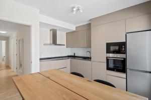 Una cocina con una mesa de madera y un refrigerador. en Penthouse in Fuengirola by Costarentals - Ref 215, en Fuengirola