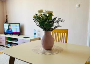 a vase of flowers sitting on a table at Maria Apartment at Rootsi street in Kuressaare