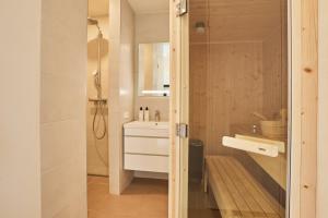 a bathroom with a shower and a white sink at Zeegser Duinen Suitelodges in Zeegse