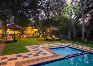 a backyard with a pool with a table and chairs at Grand Kalundawa Resort in Dambulla