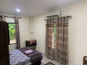 Wakaf BaharuにあるKastana Homestay IIのベッドルーム1室(ベッド1台付)、窓(カーテン付)