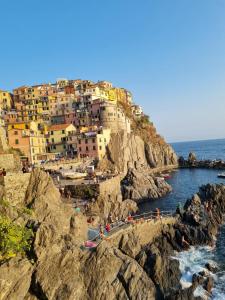 un grupo de personas de pie en una playa rocosa en CA' FRA e OLY Cinque Terre, Lerici, wifi, aria condizionata, en Castelnuovo Magra