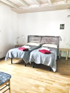 1 dormitorio con 2 camas y suelo de madera en Casa del Nespolo, en Pilzone