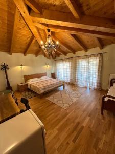 Habitación grande con cama y lámpara de araña. en Guesthouse Marku - Mrizi i Zanave, en Fishtë