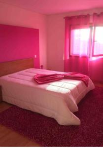 1 dormitorio con 1 cama blanca grande y paredes rosas en Refúgio Sereno, Casa na Montanha com Piscina Privativa, en Braga