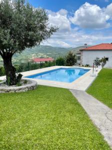 una piscina en un patio con un árbol en Refúgio Sereno, Casa na Montanha com Piscina Privativa, en Braga