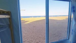 een uitzicht op het strand door een glazen schuifdeur bij Homestay Bọt Biển in Phú Hiệp