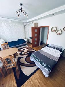 a bedroom with two beds and a table and a rug at Apartament REJA CENTRUM in Kętrzyn