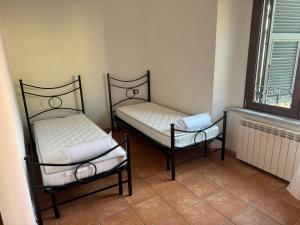 twee bedden in een kamer met een raam bij Casa Nanda in Carrara