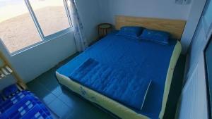 een blauw bed in een kamer met een raam bij Homestay Bọt Biển in Phú Hiệp