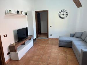 een woonkamer met een bank en een tv bij Casa Nanda in Carrara