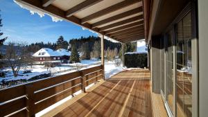 a porch of a house with snow on the ground at LA MAISON Titisee - Boutique Design Villa im Schwarzwald in Titisee-Neustadt