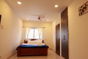 a bedroom with a bed with a ceiling fan at Marvel Homestay in Yercaud