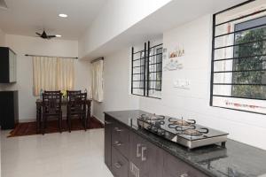 a kitchen with a stove and a counter top at Marvel Homestay in Yercaud