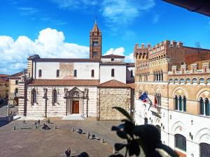 un antiguo edificio con una torre de reloj y una iglesia en Appartamento Piazza Dante Alighieri en Grosseto