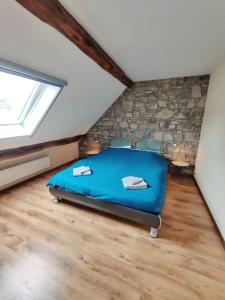 - une chambre mansardée avec un lit bleu dans l'établissement Duplex 130 m2 avec terrasse à Sassor (Theux), à Theux
