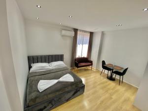 um quarto com uma cama, uma mesa e cadeiras em Mara Central Apartment 4 em Tirana