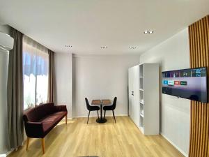 uma sala de estar com um sofá, uma mesa e uma televisão em Mara Central Apartment 4 em Tirana