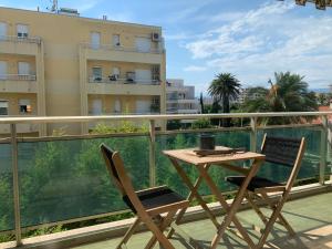 une table et des chaises sur le balcon d'un bâtiment dans l'établissement Studio Cannes bord de mer, à Cannes