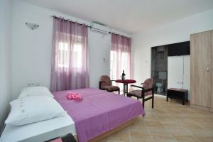 a bedroom with a bed with a pink towel on it at Apartmani Mihovic - JAZ in Budva