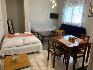 sala de estar con 2 camas, mesa y sillas en Ο ΦΟΙΝΙΚΑΣ ΣΤΗΝ ΚΑΣΤΟΡΙΑ en Kastoria