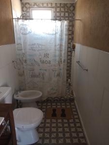 a bathroom with a toilet and a shower with a shower curtain at Espectacular Cabaña En Valle Grande Terraza Panorámica 360 in Valle Grande