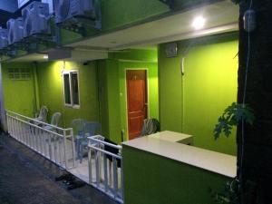 a room with green walls and tables and chairs at Lucky Guest House in Phi Phi Islands