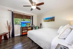 a bedroom with a bed and a flat screen tv at White Sands Village#231 in Kailua-Kona