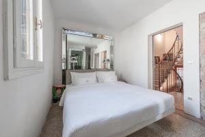 a bedroom with a white bed and a mirror at G House in Venice