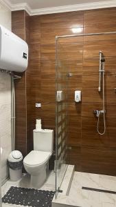 y baño con aseo y cabina de ducha de cristal. en Карпати Кайзервальд апарт, en Karpaty