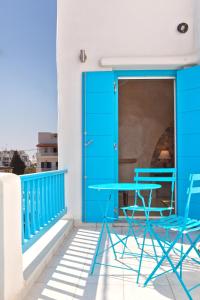 a blue table and two chairs on a balcony at TINOS AQUA PALAZZO in Tinos Town