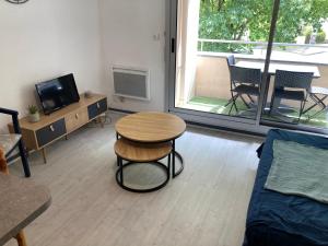 a living room with a table and a couch at Appartement plage sables blancs in Douarnenez