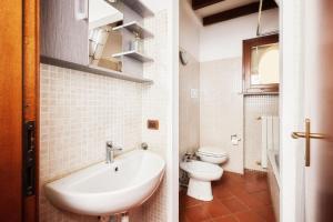 ein weißes Bad mit einem Waschbecken und einem WC in der Unterkunft Il Lusso Della Semplicità in Piacenza