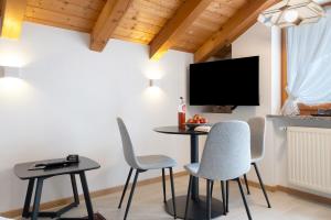 - une salle à manger avec une table, des chaises et une télévision dans l'établissement Mayr Apartments sechs, à Plaus