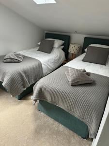 two beds sitting in a room with at Cosy Cottage in the Norfolk Countryside in Whissonsett