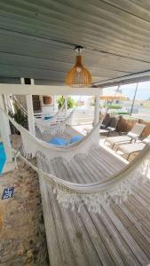 a white hammock on a porch with chairs at La Jamaca in La Parguera