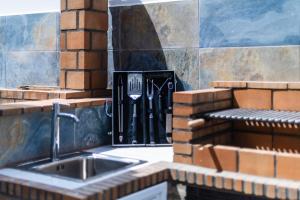 a kitchen counter with a sink and a grill at Villa De Marcos alojamiento de lujo con piscina privada in Arona