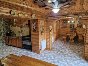 - une cuisine dans une cabane en rondins avec cuisinière dans l'établissement Гуцульська хата, à Yaremtche