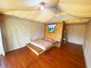 Pengalongan的住宿－Buana Glamping，帐篷内一间卧室,配有一张床