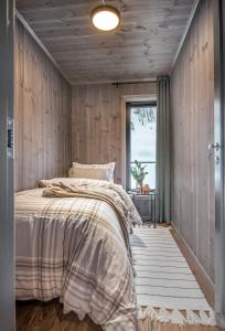 1 dormitorio con paredes de madera y 1 cama con ventana en Exclusive Cabin Apartment with Sauna - 501 en Stranda