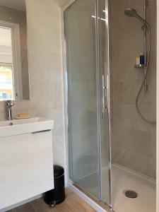 La salle de bains est pourvue d'une douche avec une porte en verre. dans l'établissement Studio Cannes bord de mer, à Cannes